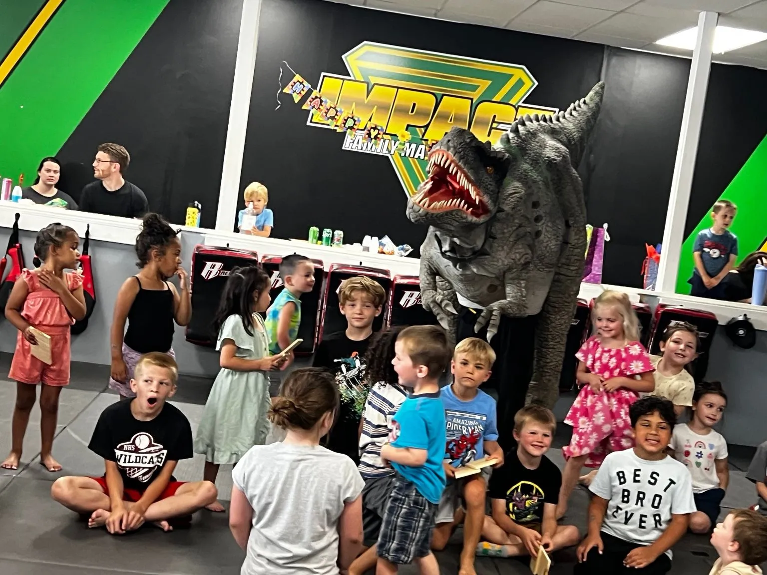 Children gathered in the real Impact dojo with Rexy the T-Rex during a birthday party